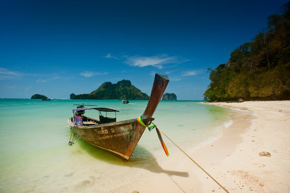 Bateau longtail traditionnel sur plage turquoise a Krabi en Thailande
