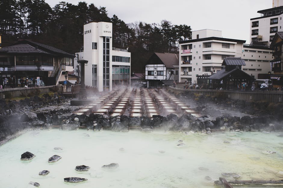 Source chaude japonaise avec vapeur qui monte entre des batiments traditionnels