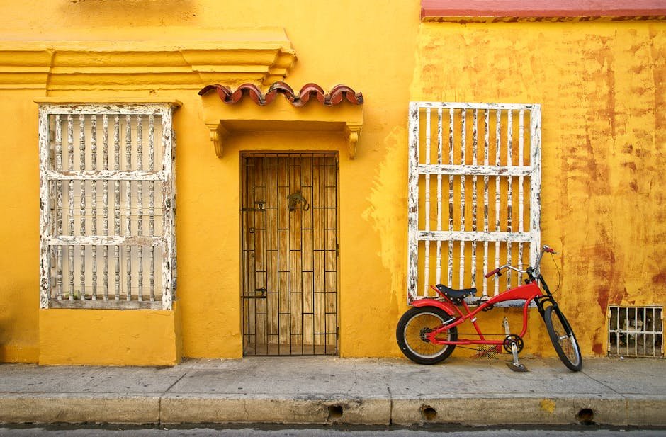 Vélo rouge devant mur jaune architecture rustique Carthagène