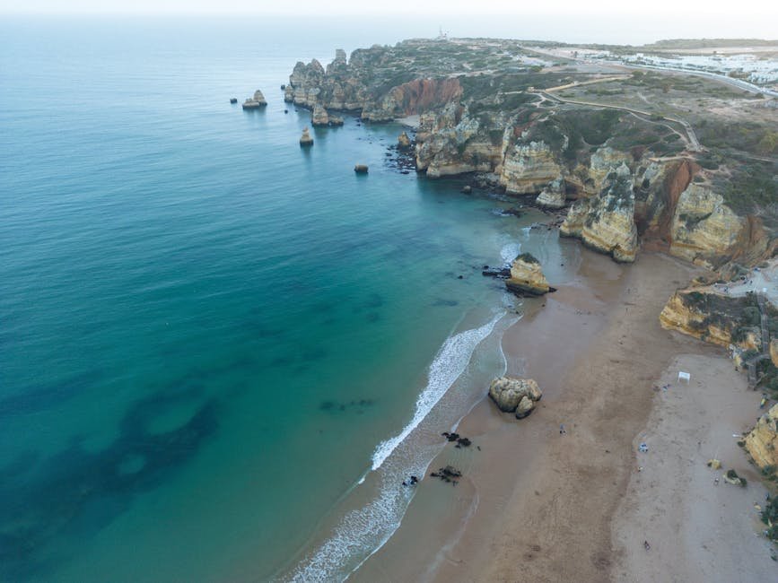 Plage de sable doré bordée de falaises impressionnantes à Lagos au Portugal