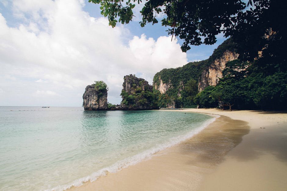 Plage tropicale avec falaises calcaires et eau turquoise en Thailande
